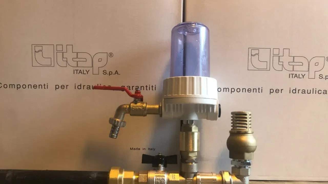 Componenti idraulici in ottone con filtro e rubinetto, parte di un sistema a pompa a colpo d'ariete.