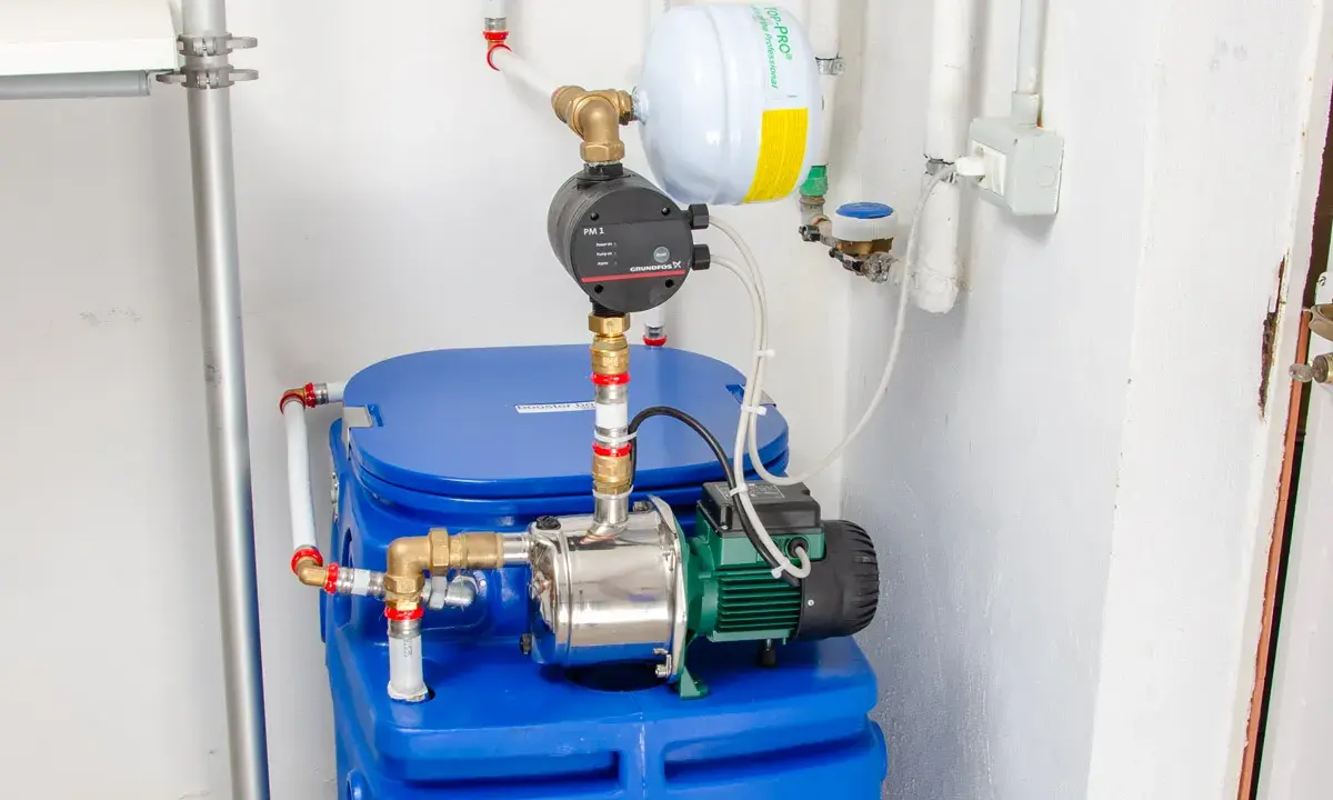 Impianto idraulico con serbatoio blu, pompa e vaso di espansione. Un autoclave per aumentare pressione acqua, pronto all'uso.