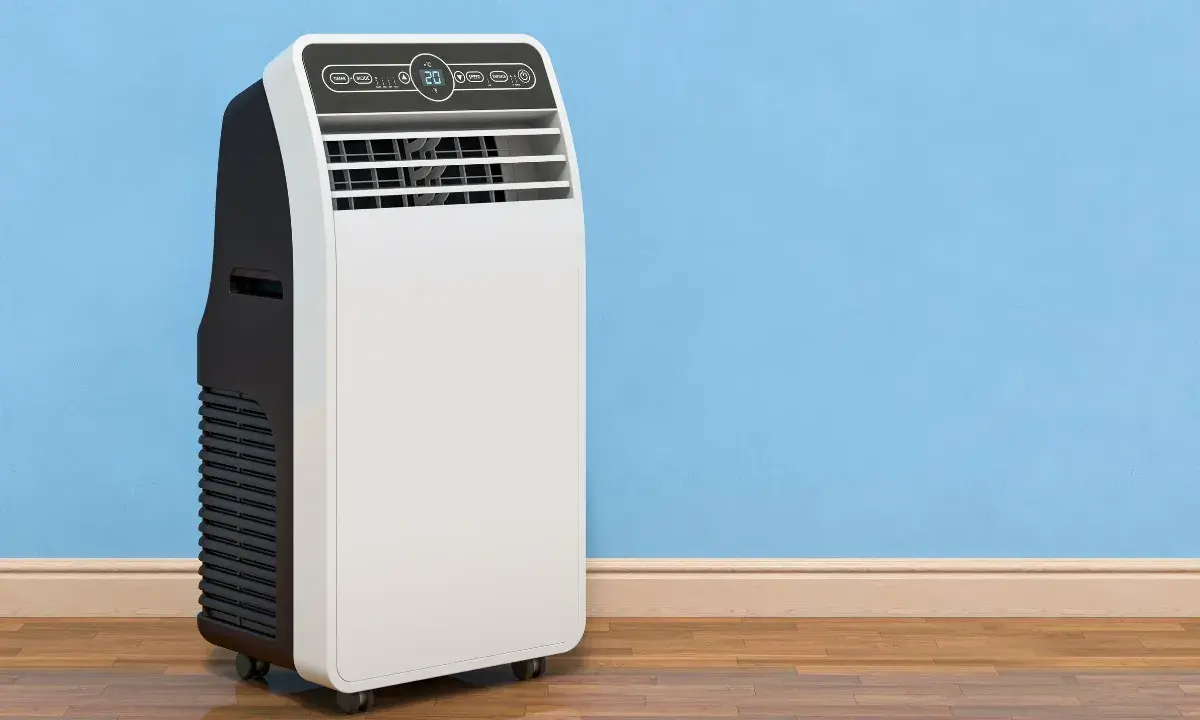 Un condizionatore portatile come funziona: un'unità bianca e nera su ruote, con display digitale, accanto a un muro blu.