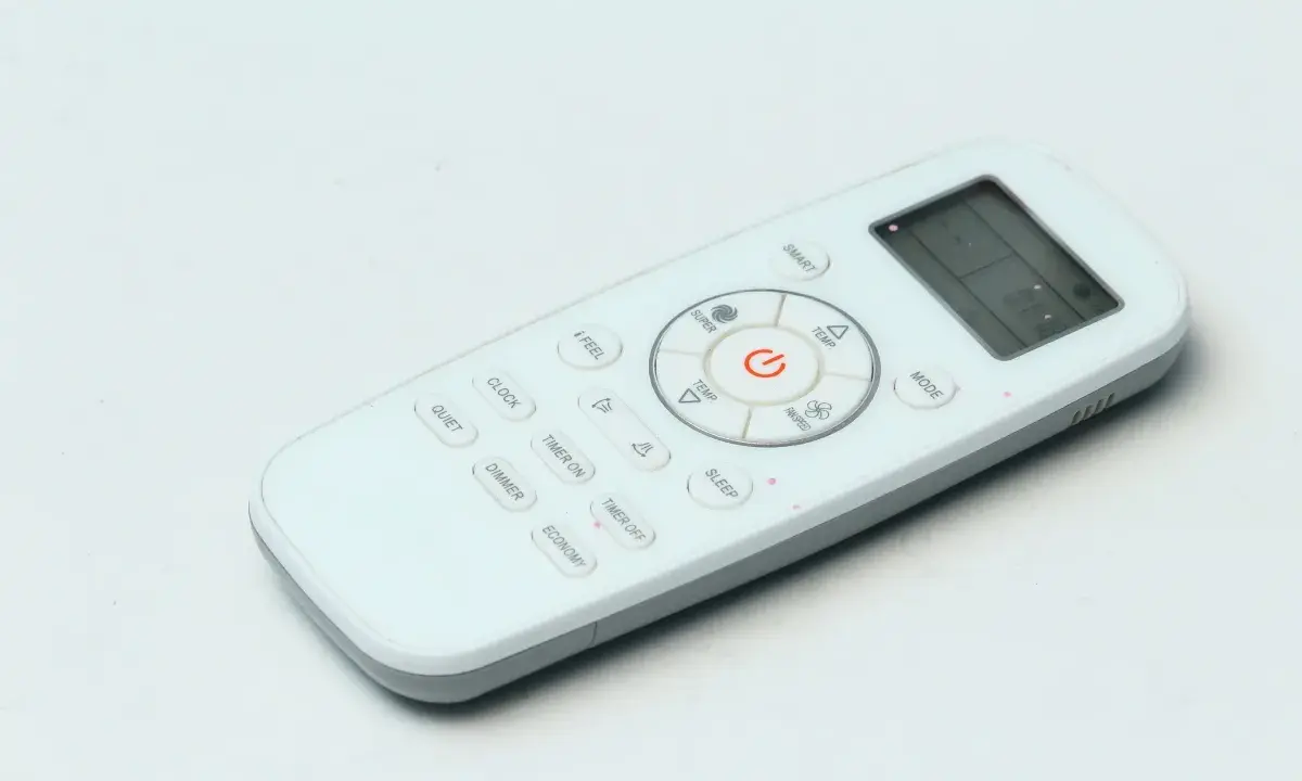 Telecomando bianco con vari simboli condizionatore: ON/OFF, temperatura, modalità, timer, sleep, smart, quiet, dimmer, economy.
