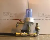 Componenti idraulici in ottone con filtro e rubinetto, parte di un sistema a pompa a colpo d'ariete.