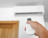 Mano che regola la temperatura condizionatore con telecomando.