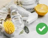 Aceto, bicarbonato e limone: ingredienti naturali per il trattamento delle acque e la pulizia ecologica. Spazzola gialla e foglioline verdi.