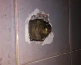 Parte interna di un rubinetto in ottone, incassato nel muro piastrellato. La chiusura del rubinetto acqua senso è necessaria per evitare perdite.