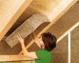 Donna installa pannelli isolanti in fibra di legno, il miglior isolante termico per soffitto, per un tetto efficiente.