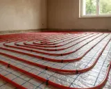 Tubature rosse per riscaldamento a pavimento disposte a spirale su una griglia.