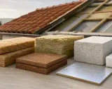 Vari tipi di materiale isolante calore, da fibre naturali a schiume, pronti per l'installazione su un tetto in costruzione.