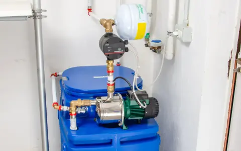 Impianto idraulico con serbatoio blu, pompa e vaso di espansione. Un autoclave per aumentare pressione acqua, pronto all'uso.