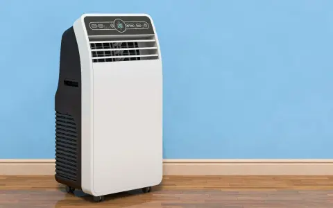 Un condizionatore portatile come funziona: un'unità bianca e nera su ruote, con display digitale, accanto a un muro blu.