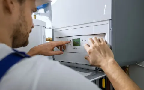 Tecnico che controlla il display della caldaia in blocco, impostando la temperatura.