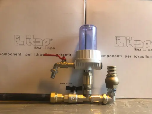 Componenti idraulici in ottone con filtro e rubinetto, parte di un sistema a pompa a colpo d'ariete.