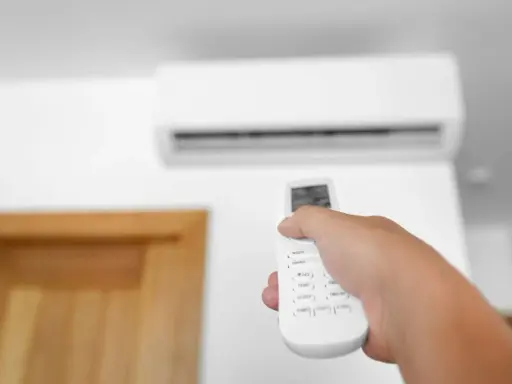 Mano che regola la temperatura condizionatore con telecomando.