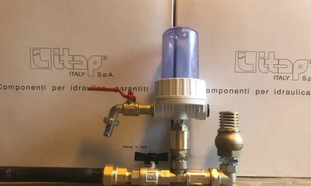 Componenti idraulici in ottone con filtro e rubinetto, parte di un sistema a pompa a colpo d'ariete.