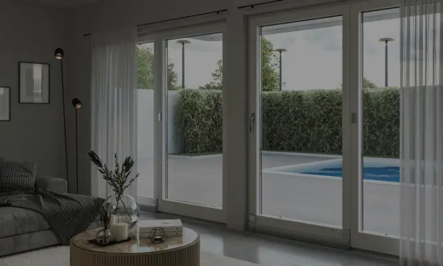 Soggiorno moderno con grandi vetrate che si affacciano su una piscina. L'isolamento acustico garantisce tranquillità.