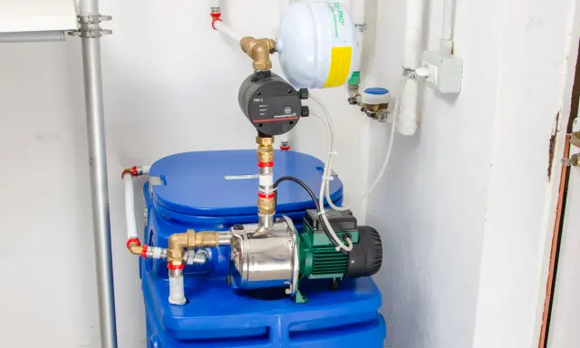 Impianto idraulico con serbatoio blu, pompa e vaso di espansione. Un autoclave per aumentare pressione acqua, pronto all'uso.