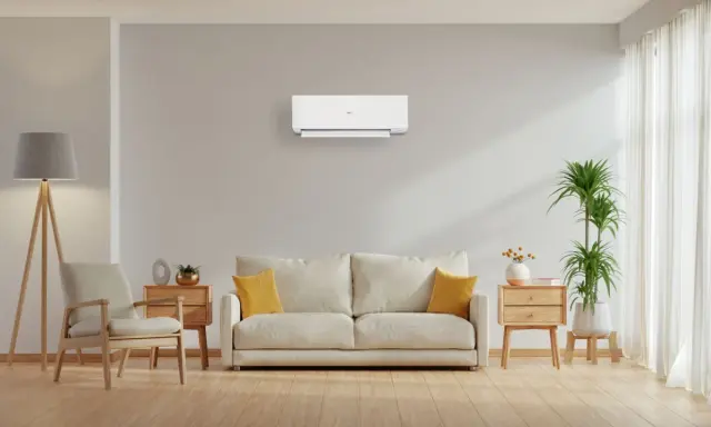 Un soggiorno moderno con un condizionatore a parete, che illustra la differenza tra pompa di calore e condizionatore.
