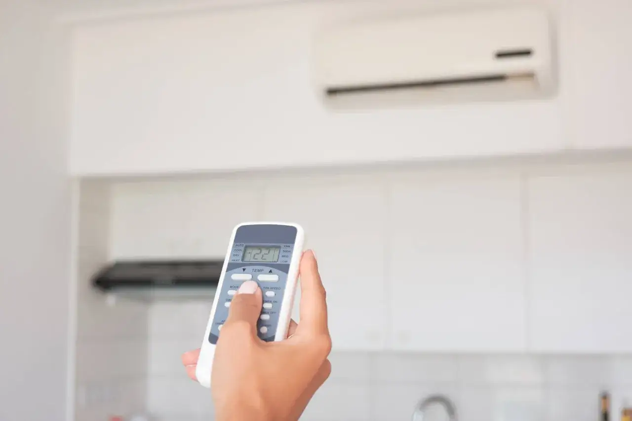 Mano che regola il dry condizionatore con il telecomando, impostando la temperatura a 22 gradi.
