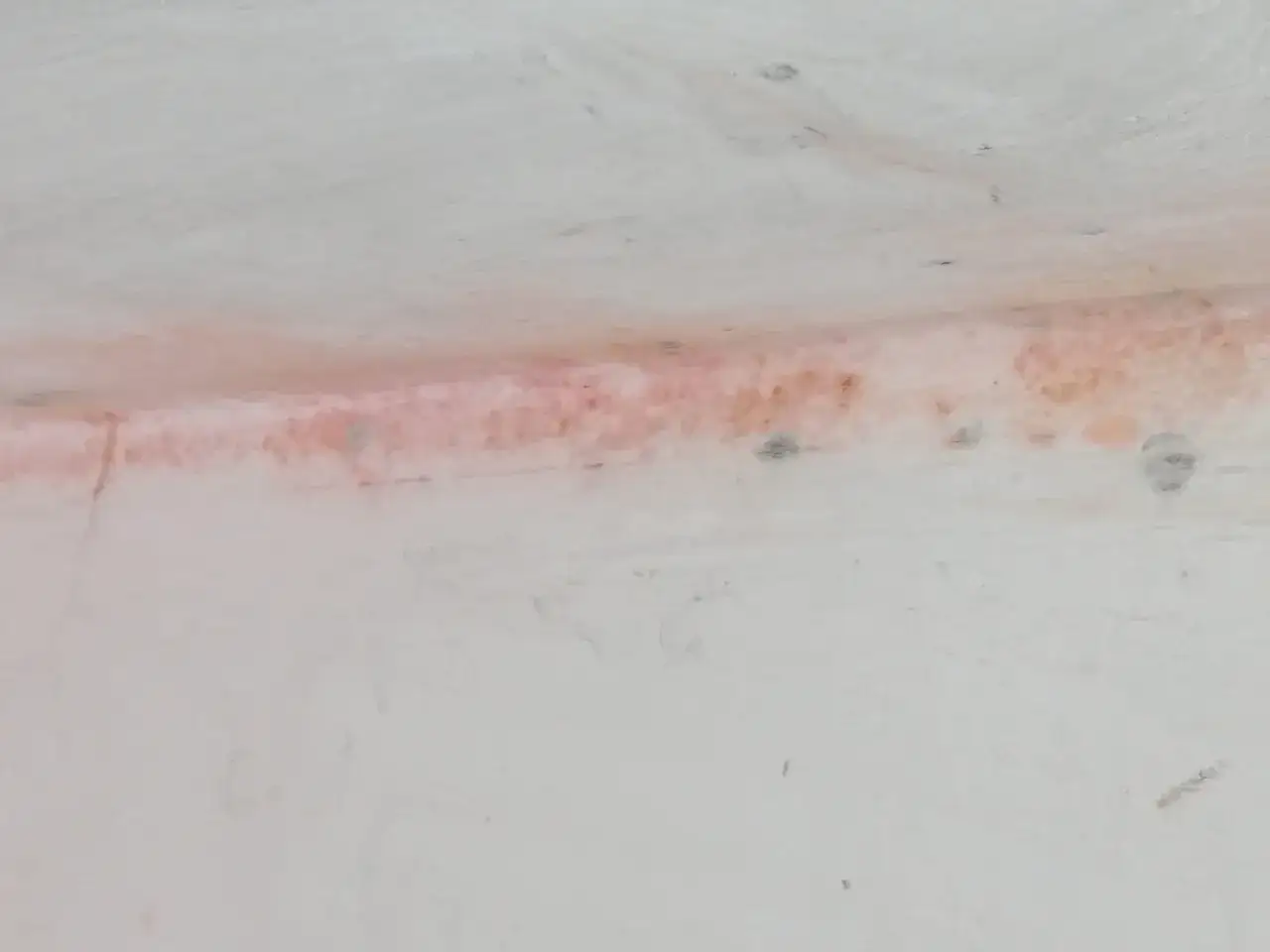 Macchie di muffa rossa sul muro, segno di umidità e potenziale problema da affrontare.
