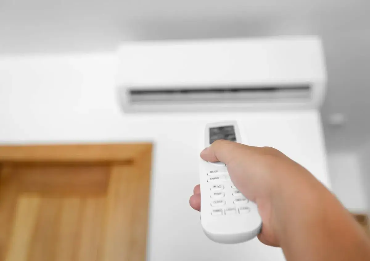 Mano che regola la temperatura condizionatore con telecomando.