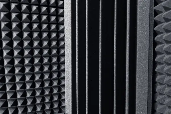 Pannelli fonoassorbenti con texture a piramide e a listelli, ideali come miglior isolante acustico per studi di registrazione.