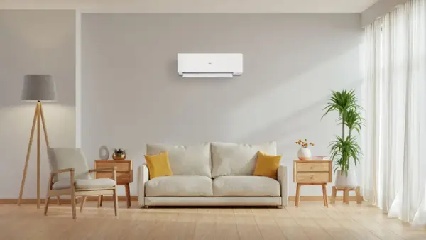 Un soggiorno moderno con un condizionatore a parete, che illustra la differenza tra pompa di calore e condizionatore.